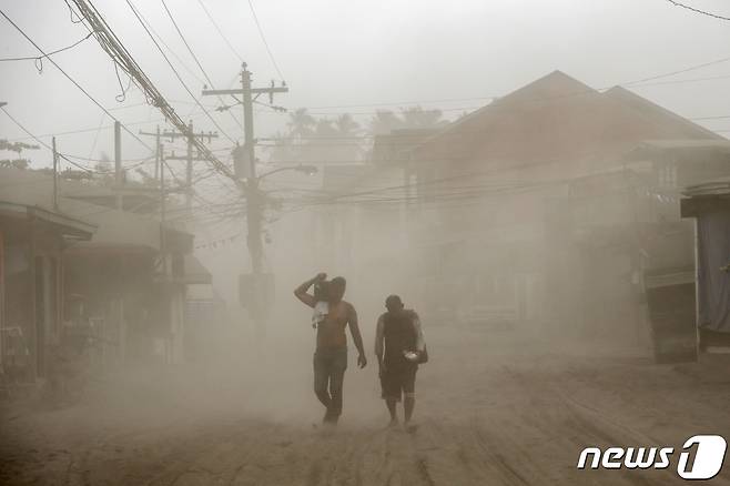 13일 탈화산 인근 마을 주민들이 자욱한 화산재를 뒤로 하고 마을 빠져나오고 있다. © 로이터=뉴스1 © News1