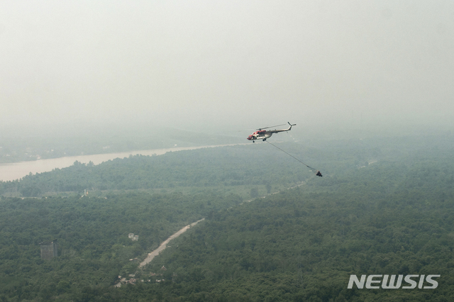 [AP/뉴스] 2019년 9월 인도네시아에서 가장 북쪽에 위치한 보르네오섬의 중앙 칼리만탄주에서 스모그 속에 헬리콥터가 산불 예방의 물 폭탄 투하 연습을 하고 있다. 보르네오섬 동 칼리만탄주로 새 수도를 옮기는 공사가 올 하반기 시작된다. 스모그는 화재 연기에서 비롯된다.  2020. 1. 17.