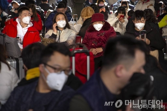 중국 베이징 열차역에서 마스크를 쓰고 열차를 기다리고 있는 승객들