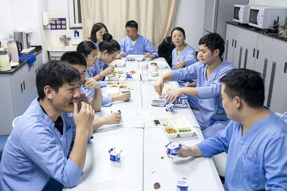 중국 의료진이 춘절 전야인 섣달 그믐날밤 가족들이 둘러앉아 먹는 '녠예판' 대신 도시락과 요구르트를 먹으며 잠시 휴식을 취하고 있다. [중국 신화망, 슝치]