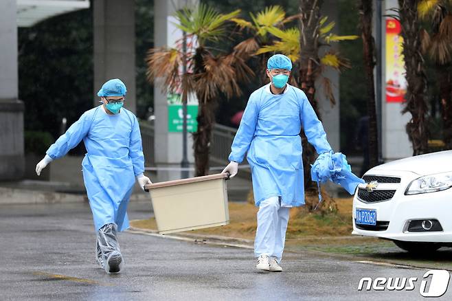 지난 10일 중국 후베이성 우한에서 의료진이 신종 코로나바이러스로 인한 폐렴 환자가 치료 중인 진인탄병원을 걸어가면서 상자를 들고 있다. © 로이터=뉴스1 © News1 이동원 기자