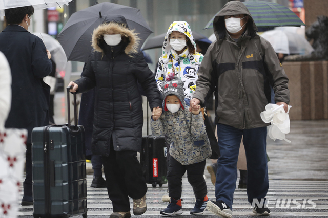[도쿄=AP/뉴시스]마스크를 쓴 중국 관광객들이 28일 일본 도쿄 거리를 걷고 있다. 2020.01.28