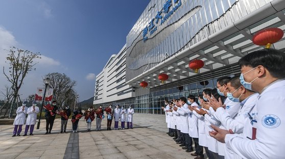 신종 코로나바이러스에 감염됐다가 중국 저장대 제1의원에서 치료를 받고 퇴원하는 사람들에게 의료진이 박수를 보내고 있다. [중국 신화망 캡처]
