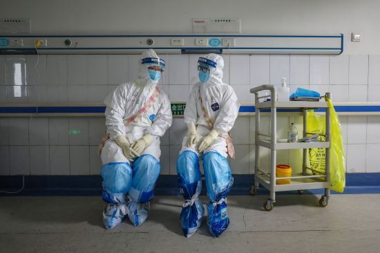 중국 후베이성 우한시 적십자병원에서 16일 방호복을 착용한 의료진이 잠시 휴식을 취하며 대화를 나누고 있다. AFP/연합뉴스