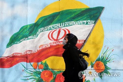 이란국기가 그려진 벽화앞을 지나는 이란 시민 [EPA=연합뉴스 자료사진]