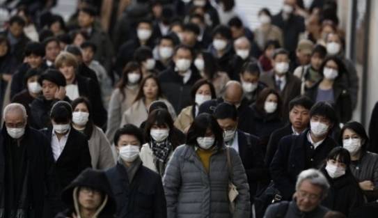 신종 코로나바이러스(코로나 19)의 충격이 확대되고 있는 가운데 18일 일본 도쿄의 직장인들이 대거 마스크를 착용하고 걸어가고 있다. 도쿄AP/연합뉴스 제공