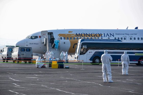 지난 1일 중국 우한에서 전세기를 타고 도착한 몽골인들이 울란바토르 공항에 내리고 있다. [AFP=연합뉴스]