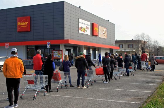23일 신종 코로나 확진자가 급증한 이탈리아의 카살푸스테렌고의 한 슈퍼마켓 앞에서 주민들이 생필품을 사기 위해 슈퍼 문이 열리기를 기다리고 있다. [EPA=연합뉴스]