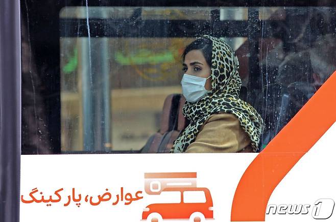 24일 이란 수도 테헤란에서 한 버스를 탄 여성이 마스크를 착용하고 있다. © AFP=뉴스1