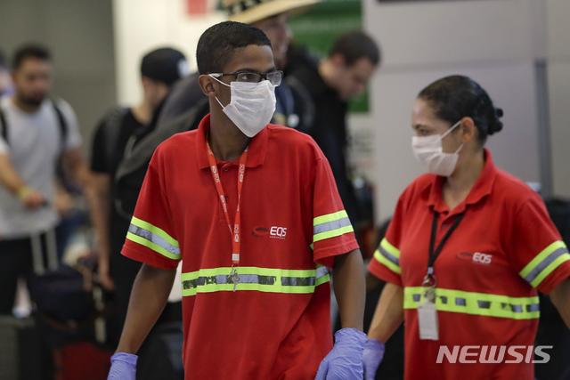 [상파울루=AP/뉴시스]26일(현지시간) 브라질 상파울루 국제공항에서 신종 코로나바이러스 감염증(코로나19) 확산 사태에 대비해 공항 직원들이 마스크를 착용한 채 일하고 있다. 2020.2.27.