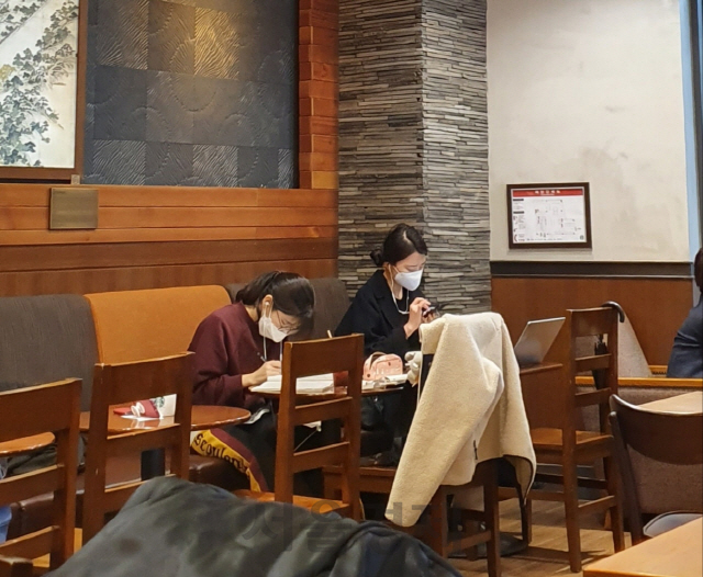 지난 27일 서울 종로구 한 프랜차이즈 카페에서 마스크를 착용한 방문객들이 공부를 하고 있다. /이희조기자