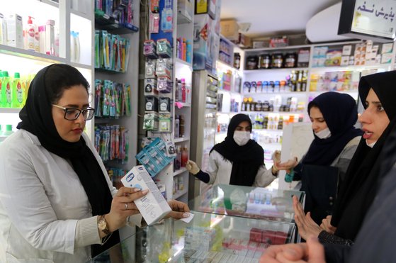 마스크를 쓴 이란인들이 약국에서 마스크를 구입하려고 하고 있다. [AFP=연합뉴스]