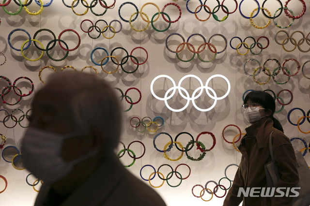 [도쿄=AP/뉴시스] 지난달 23일 마스크를 낀 시민들이 일본 도쿄의 올림픽 박물관을 지나고 있다. 2020.2.26.