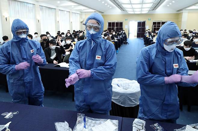 ⓒ연합뉴스3월5일 신규 공중보건 의사들이 코로나19 현장 배치 대비 직무교육을 받으며 보호장비를 착용하고 있다.