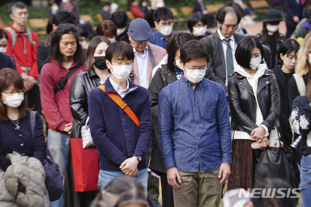 [도쿄=AP/뉴시스]지난 11일 일본 도쿄에서 시민들이 마스크를 쓴채 2011년 3월 11일 발생한 동일본대지진의 희생자들을 추모하고 있다. 2020.03.13