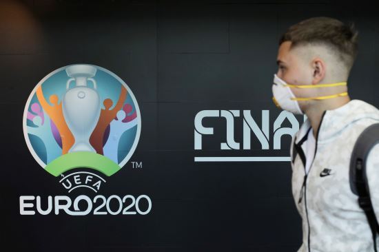 마스크를 쓴 한 승객이 16일 루마니아 오코페니의 부쿠레슈티 헨리 코안더 국제공항 내벽에 붙어있는 유로2020 로고 옆을 지나가고 있다. 로이터연합뉴스