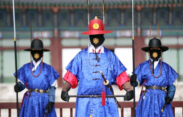 14일 오후 서울 경복궁에서 수문장들이 도깨비 문양이 들어간 마스크를 쓰고 있다. 연합뉴스
