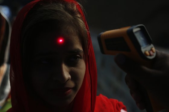 한 파키스탄 여성이 체온 측정을 받고 있다. 파키스탄은 남아시아에서 신종 코로나 감염증 확진자가 가장 많이 발생한 나라다. [AP=연합뉴스]