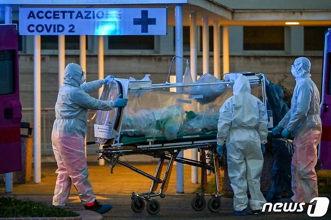 신종 코로나바이러스 감염증(코로나19) 환자를 이송하는 이탈리아 의료진. © AFP=뉴스1