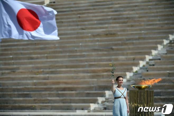 (아테네 AFP=뉴스1) 그리스 배우 산티 게오르기오가 19일 (현지시간) 아테네에서 열린 도쿄 올림픽 성화 인수식에서 성화를 들고 있다.   ⓒ AFP=뉴스1