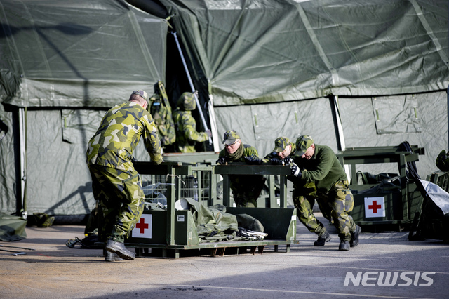 [고센버그=AP/뉴시스] 23일(현지시간) 스웨덴의 군인들이 고센버그 지역의 병원 옆에 신종 코로나바이러스 감염증(코로나19) 중환자를 위한 비상용 야전병원을 짓고 있다. 2020.3.24.