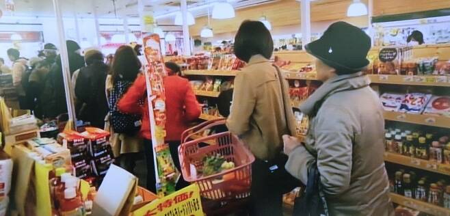 지난 25일 오후 일본 도쿄의 한 슈퍼마켓에서 쌀 등 식료품을 사려는 손님들이 줄지어 서 있다. NHK 화면 캡처