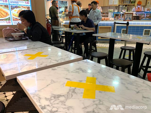싱가포르 한 대형몰 푸트코트 식탁에서 손님들이 노란 X표가 없는 자리에 앉아 식사를 하고 있다. 채널뉴스아시아 캡처