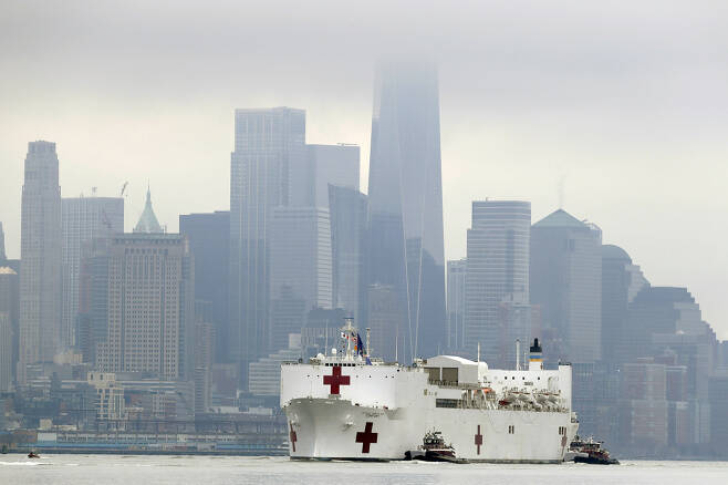 미 해군의 병원선(船) ‘컴포트’호(號)가 30일(현지시간) 뉴욕에 입항하기 위해 월스트리트 등이 있는 로어맨해튼 지역을 지나고 있다. 이 배엔 1000개 병상과 12개의 수술실 등이 있어 코로나19 피해로 고통받은 뉴욕을 지원할 걸로 기대된다. [AP]