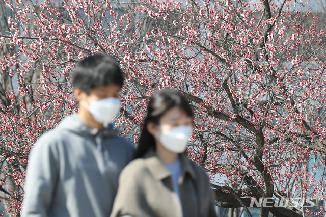 [서울=뉴시스] 이윤청 기자 = 나들이 나온 시민들이 22일 서울 여의도 한강공원에서 마스크를 쓴 채 걷고 있다. 2020.03.22. radiohead@newsis.com