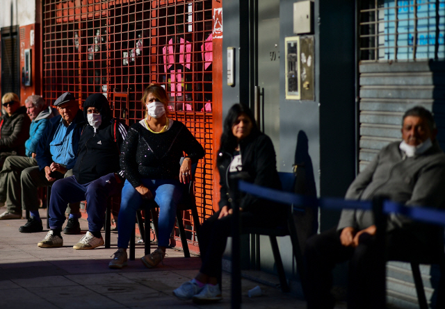4일(현지시간) 아르헨티나 부에노스아이레스의 한 은행 앞에 연금을 인출하려는 사람들이 일정한 간격을 유지한 채 의자에 앉아 차례를 기다리고 있다./부에노스아이레스=AFP연합뉴스