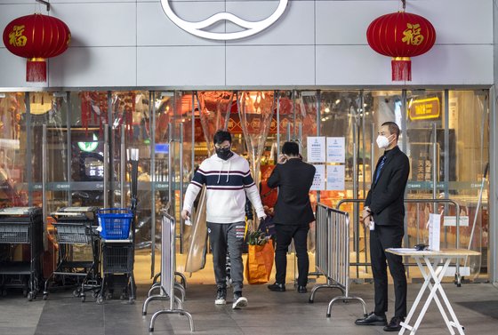 지난 2월 3일 중국 광둥성 광저우 시내 한 쇼핑몰 앞아서 보안요원이 방문객의 마스크 착용 여부와 체온을 체크하고 있다. EPA=연합뉴스