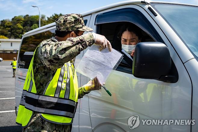 코로나19로 차량 통제 나선 주일 미군 기지 (요코스카 AFP=연합뉴스) 일본 요코스카항에 주둔하는 미 해군 기지의 보안 요원들이 10일 신종 코로나바이러스 감염증(코로나19) 을 차단하기 위해 진입 차량을 통제하고 있다. 보안 요원들은 탑승자의 상태를 묻는 설문 조사와 함께 체온 측정을 하고 있다. jsmoon@yna.co.kr