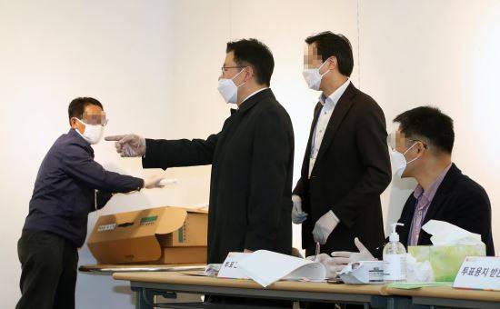 제21대 국회의원선거 서울 종로에 출마한 미래통합당 황교안 후보가 15일 서울 종로구 동성고등학교에 설치된 혜화동 제3투표소에서 기표소 가림막이 없다며 투표관리관에게 항의하고 있다. 뉴시스