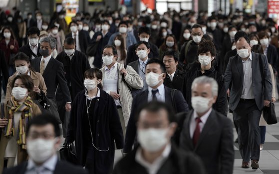 지난 17일 도쿄역에서 마스크를 쓴 채 출근을 서두르는 시민들. [EPA=연합뉴스]