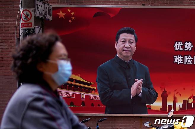 중국 상하이에서 시진핑 국가 주석 사진 앞을 한 시민이 지나가고 있다. © 로이터=뉴스1