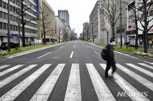 [오사카=AP/뉴시스]지난 28일 일본 오사카부의 한 텅 빈 거리를 시민이 걸어가고 있다. 오사카부는 코로나19 확산 방지를 위해 외출 자체 요청을 내렸다. 2020.03.30.