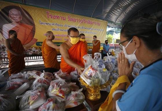 태국 수도 방콩에서 지난 1일 불교 승려들이 주민들에게 무료 식료품을 나눠주고 있다. 불교 국가인 태국의 사찰들은 코로나19 확산으로 고통 받는 주민을 위해 주민들에게 식료품과 일상 용품을 나눠주고 있다. EPA=연합뉴스