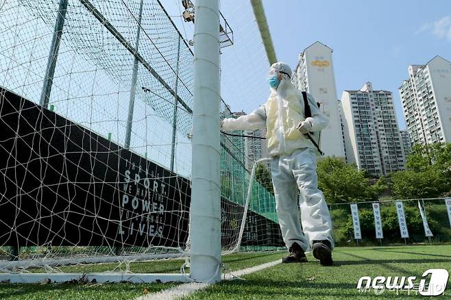 (서울=뉴스1) = 4일 오후 서울 성동구 응봉축구장에서 성동구청 관계자가 재개장에 앞서 방역 및 소독을 하고 있다. (성동구청 제공) 2020.5.4/뉴스1