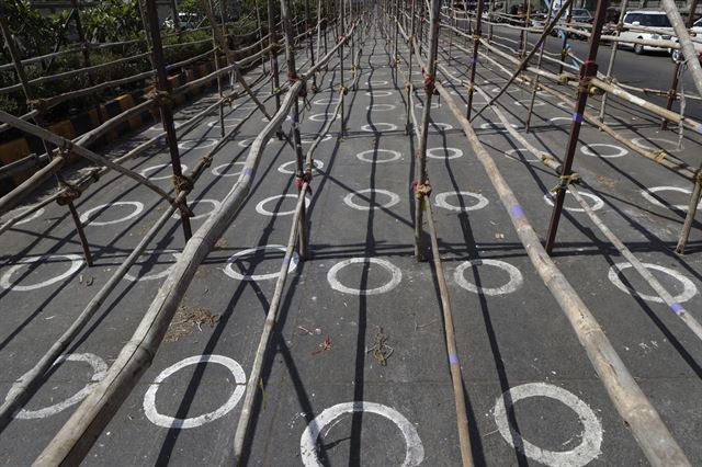 인도 뭄바이의 농산물 시장 입구에 9일 사회적 거리두기를 유지하기 위한 동그라미가 그려져 있다. 뭄바이=AP 연합뉴스