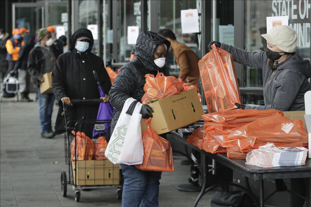 지난달 24일(현지시간) 미국 뉴욕 브루클린의 한 푸드 뱅크에서 자원봉사자들이 주민들에게 식량키트를 건네고 있다./사진=AP 연합뉴스
