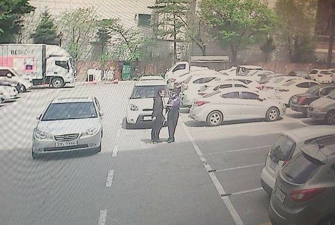 지난달 21일 서울 강북구의 한 아파트 주차장에서 이중주차 문제로 경비원 최씨(오른쪽)와 주민 심씨가 언쟁을 벌이고 있을 당시 폐회로텔레비전(CCTV) 영상. 유족 제공