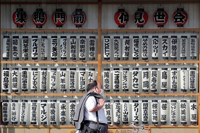 일본 도쿄에서 마스크를 쓴 남성이 상점가를 지나가고 있다. 도쿄/로이터 연합뉴스