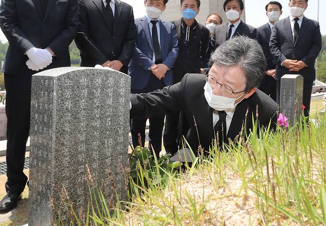 유승민 미래통합당 의원이 5·18민주화운동 40주년을 하루 앞둔 17일 광주 망월동 국립5·18민주묘지를 찾아 윤상원 열사의 묘비를 만져보고 있다. 강윤중 기자