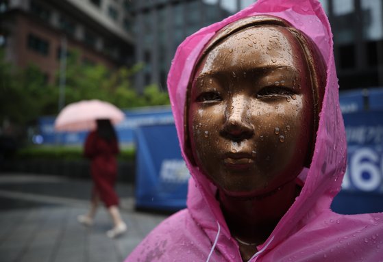 비가 내린 19일 오전 서울 종로구 옛 일본대사관 앞에 설치된 평화의 소녀상에 우비가 씌워져 있다. 연합뉴스