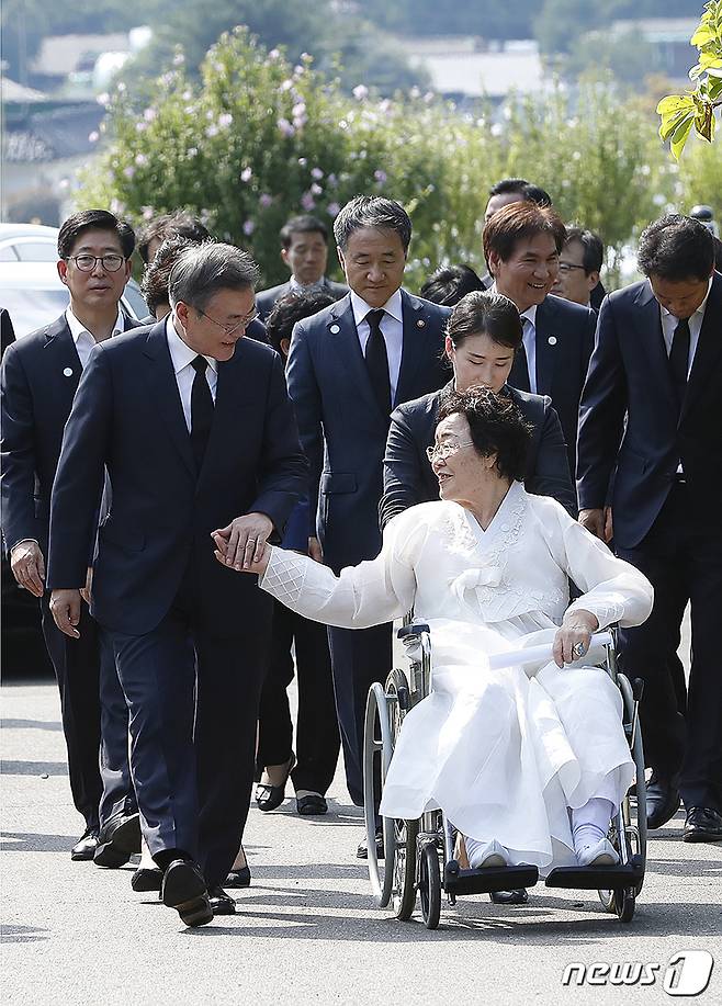 인권운동가이자 일본군 위안부 피해자인 이용수 할머니가 지난 2018년 충남 천안 국립망향의 동산에서 열린 일본군 위안부 피해자 기림의 날 기념식에서 문재인 대통령과 손을 잡고 참석하고 있다. (청와대 제공) © News1 DB