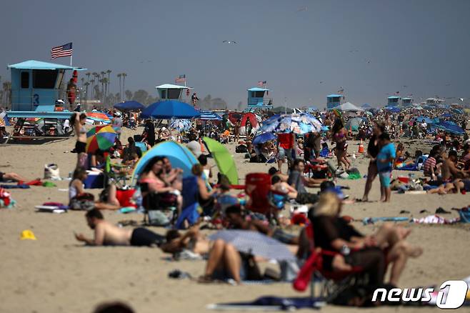 24일(현지시간) 미국 캘리포니아주 헌팅턴 해변에 인파가 몰려들어 일광욕을 즐기고 있다. © 로이터=뉴스1