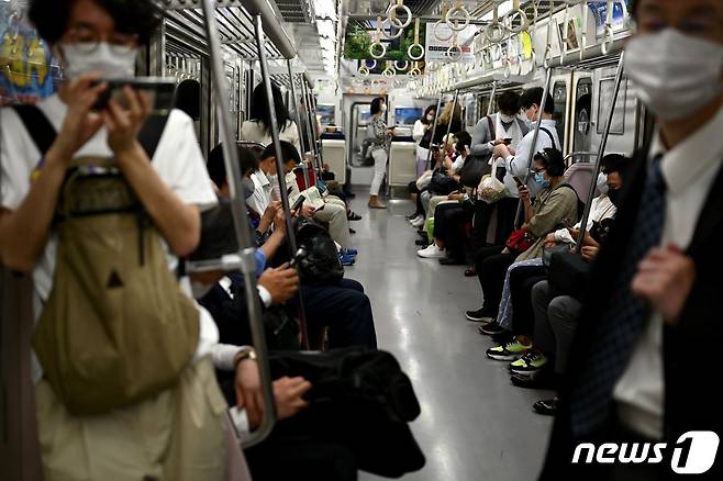 25일 일본 도쿄시내를 오가는 전철을 탄 승객들이 마스크를 착용하고 있다. © AFP=뉴스1