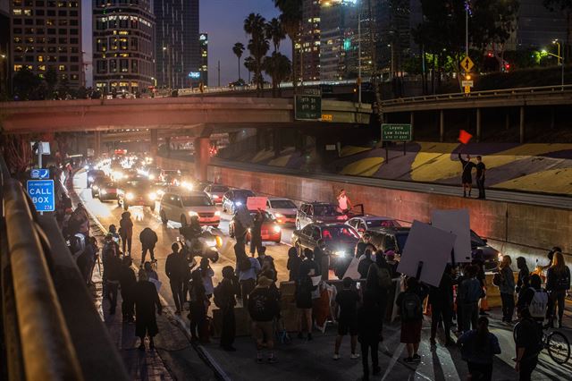 미국 전역에 경찰의 과잉 진압으로 흑인 남성이 사망한 사건에 분노한 시위가 나흘째 이어지는 가운데 29일 밤 캘리포니아주 로스앤젤레스 도심 차도를 점령했다. 로스앤젤레스=AFP 연합뉴스