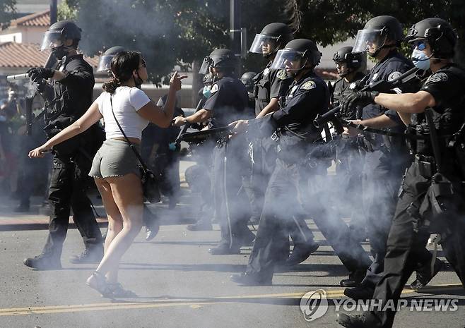 경찰에 맞서 '흑인사망' 항의하는 캘리포니아 시위대 (새너제이 AP=연합뉴스) 미국 백인 경찰의 가혹 행위로 흑인 남성 조지 플로이드가 사망한 사건에 항의하는 시위가 미전역으로 확산하는 가운데 29일(현지시간) 캘리포니아주 새너제이의 한 시위 참가자가 경찰과 맞서고 있다. leekm@yna.co.kr