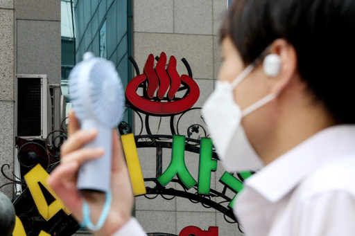 30도에 육박하는 더운 날씨를 보이는 31일 오전 서울 종로구 일대에서 한 시민이 손 선풍기를 들고 사우나 앞을 지나고 있다. 뉴시스
